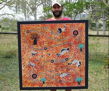 Chad Briggs holding one of his paintings