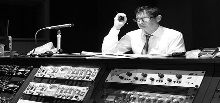 Tim Davies directing in a music studio wearing glasses
